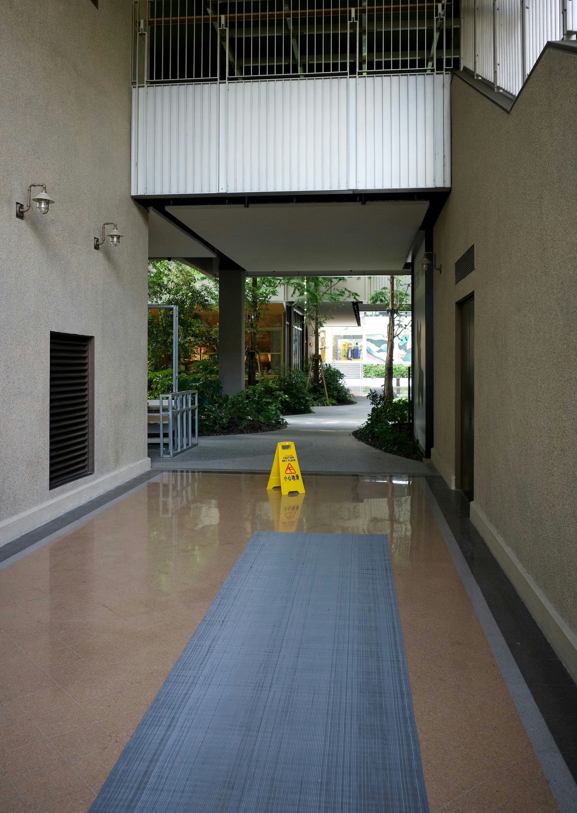 Indoor walkway with a wet floor sign and a mat